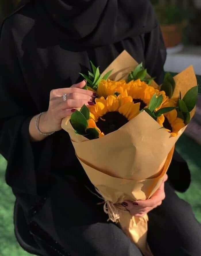 عکس دست دختر با گل آفتابگردان